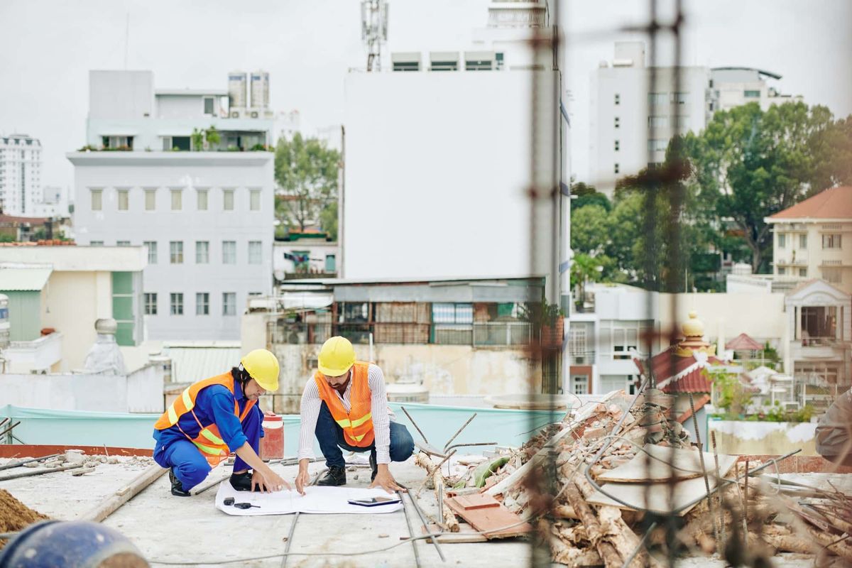 Bauarbeiter besprechen gemeinsam den Bauplan auf der Baustelle